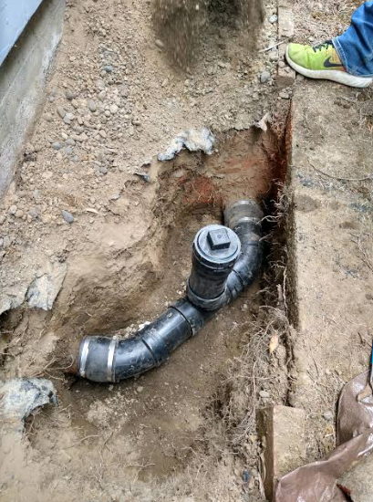 Exposed water pipe and fitting in an excavated trench during a pipe repair
